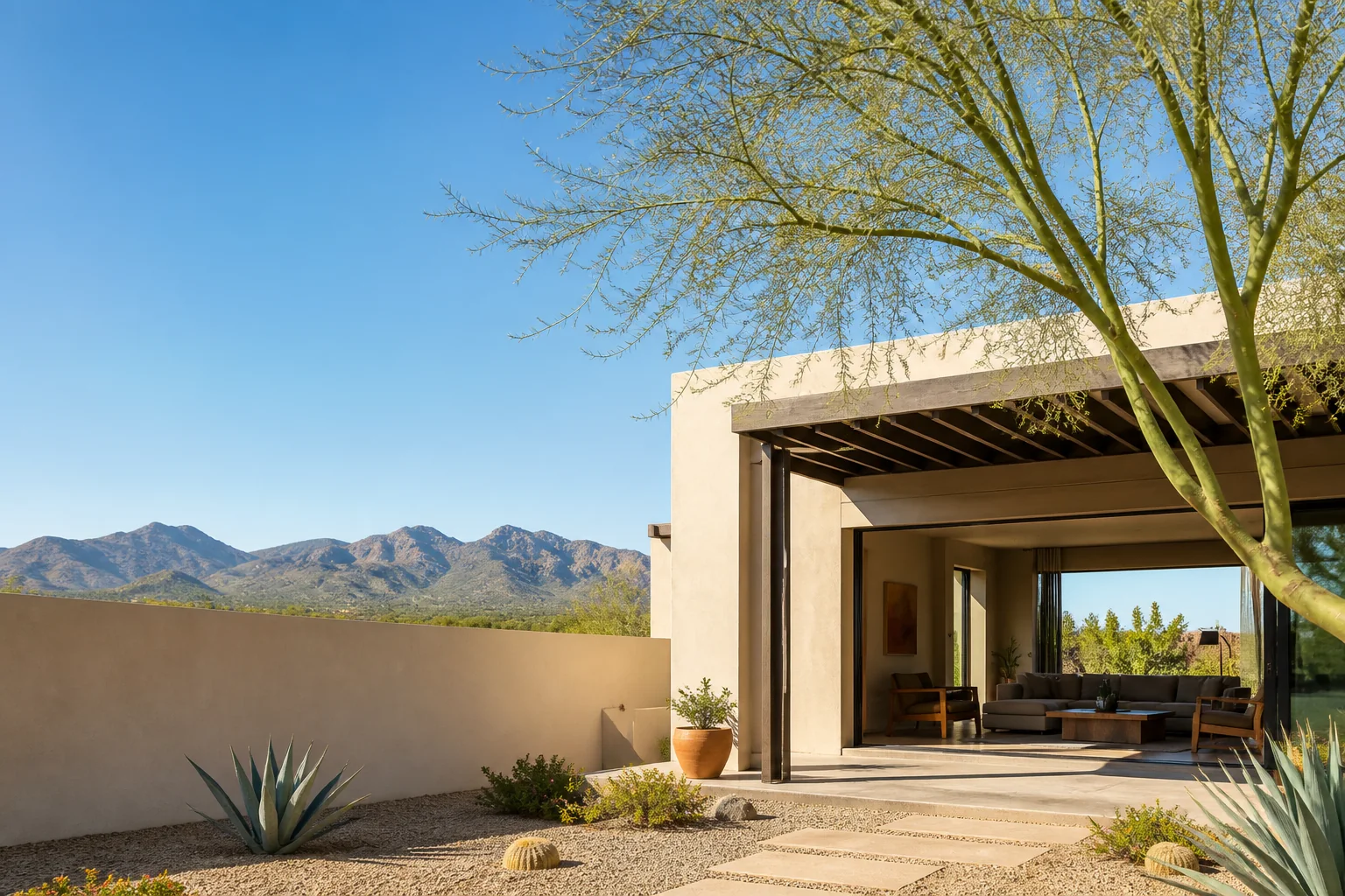 Desert-modern Phoenix home with shaded patio, palo verde tree, and mountains beyond